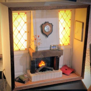 Dollhouse fireplace scene with warm glow, shield plaque above mantel, and stained-glass side windows.